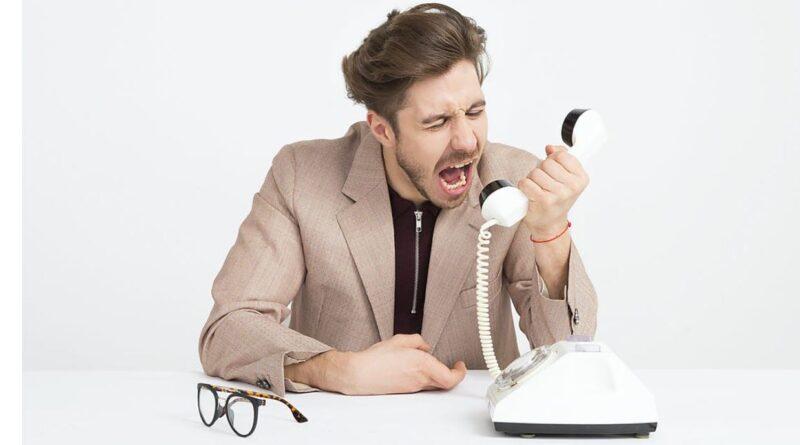 Ein frustrierter Mann schreit in den Telefonhörer. Effektive Kommunikationsstrategien im Kundenservice können solche Situationen verhindern.