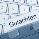 Eine Mappe eines Gutachters liegt auf einer Tastatur